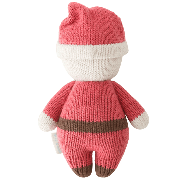 A knitted plush toy shaped like a Santa Claus figure, shown from the back. The toy features a pink knit body and hat with white accents and a brown stripe, set against a plain white background.